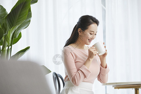 坐在客厅喝咖啡的成年女子图片