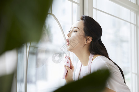 青年女子在玻璃上呼气背景图片