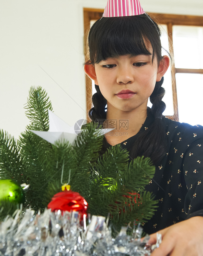 整理圣诞树的女孩图片