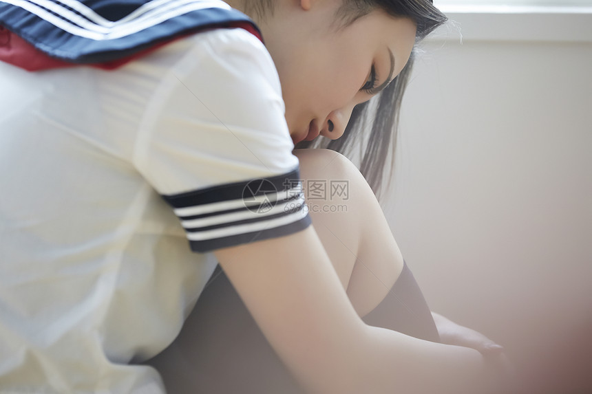 坐在地上思考困的高中女生图片