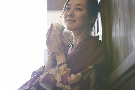 穿着日式浴衣拿着杯子的年轻女性图片