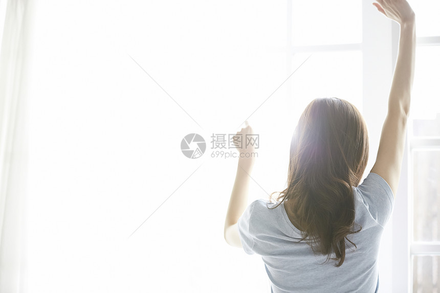 窗边女人伸展放松图片