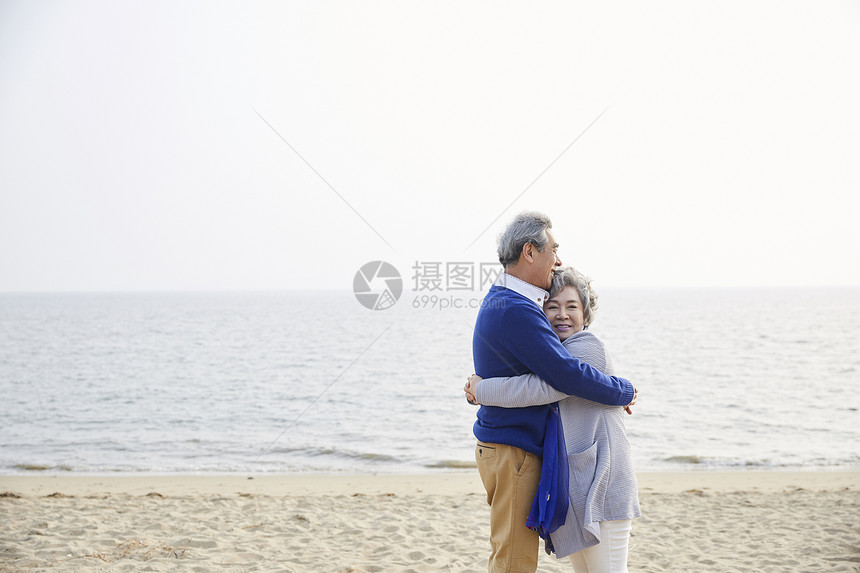 老夫妇在海边相互拥抱一起图片