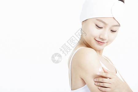 手臂涂抹乳液的年轻女子图片