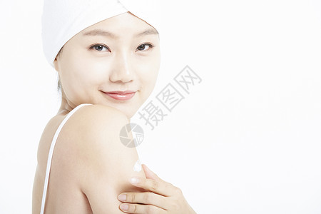 身体护理涂乳霜的青年女性图片
