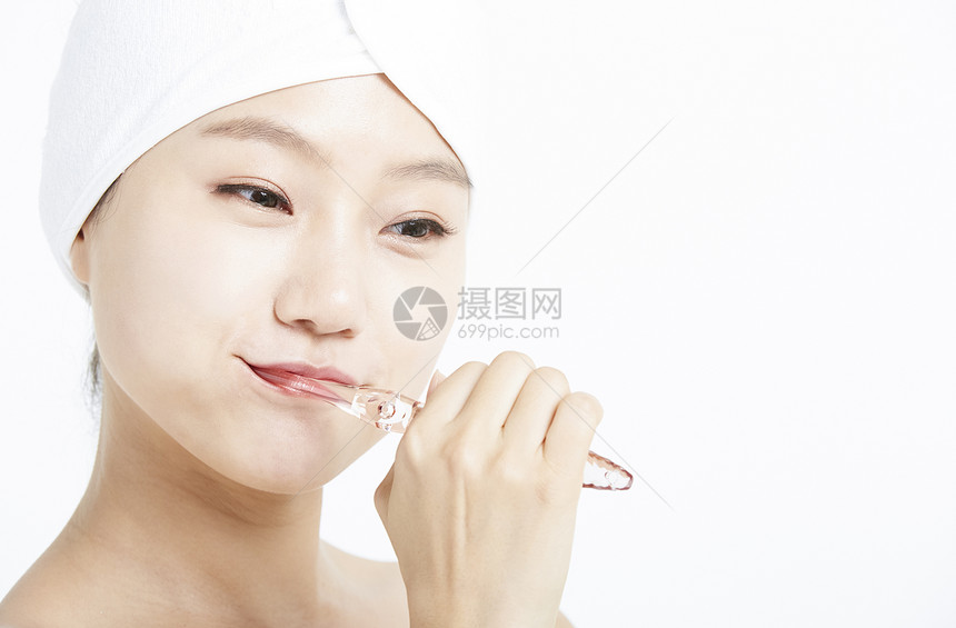 使用牙刷清洁口腔的年轻女子图片