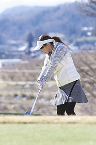 绿色室外优良女子打高尔夫球图片