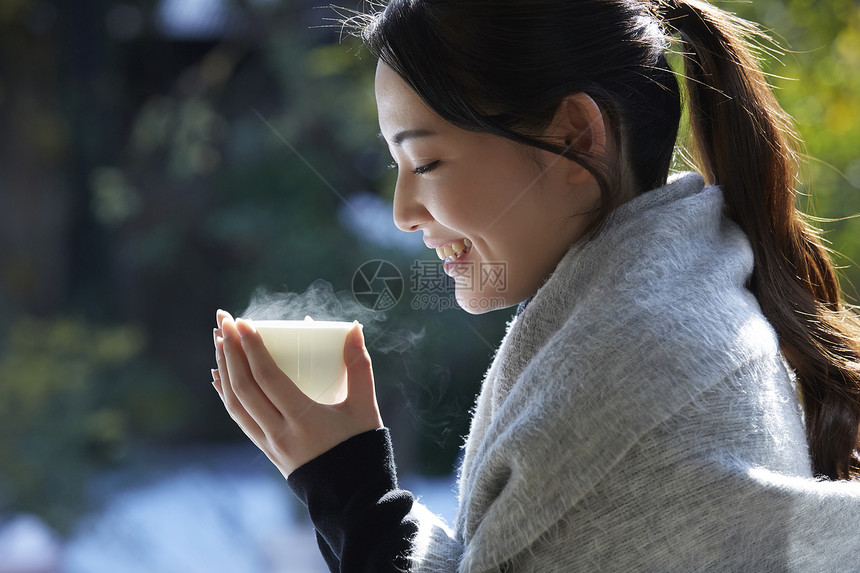 年轻女孩秋冬保暖捧着热茶图片