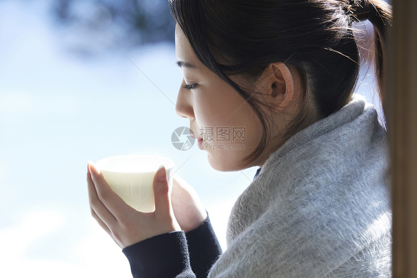 年轻女孩秋冬保暖捧着热茶图片