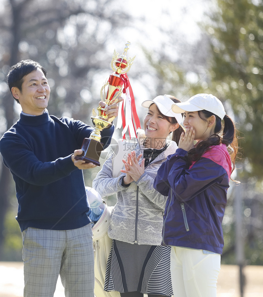 在高尔夫球球场举起奖杯图片