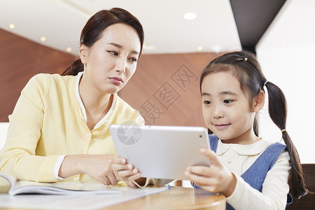 小女孩和妈妈一起看平板电脑学习图片