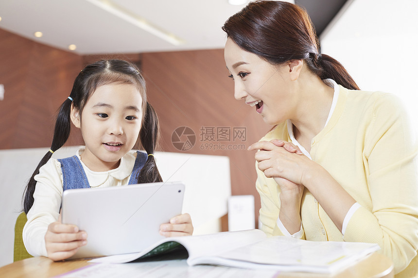 小女孩和妈妈一起看平板电脑学习图片