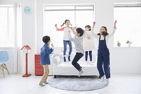 室内客厅里跳跃玩耍的小朋友高清图片