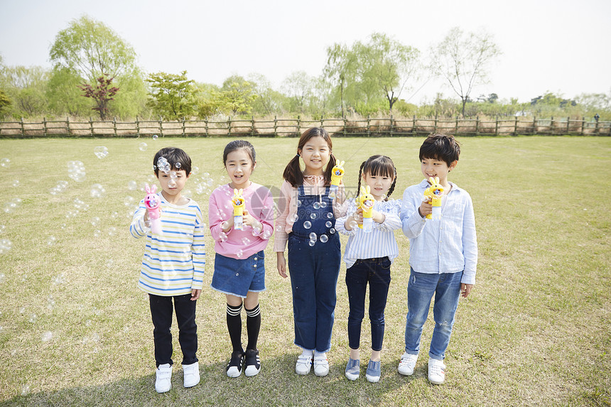 公园里拿着泡泡机的孩子们图片