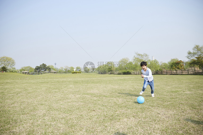 公园里玩球的小男孩图片