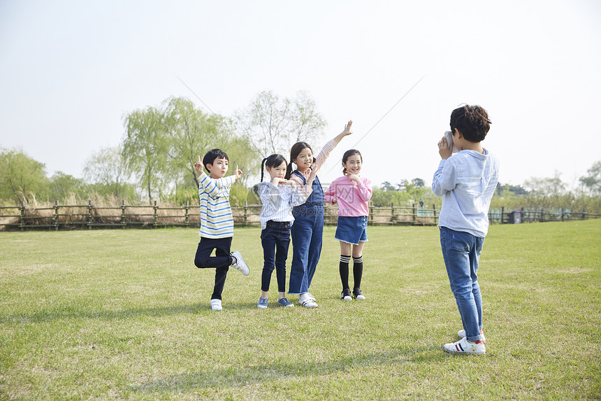 男孩在公园给朋友们拍照图片