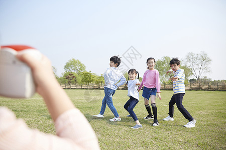 女孩在公园给朋友们拍照图片