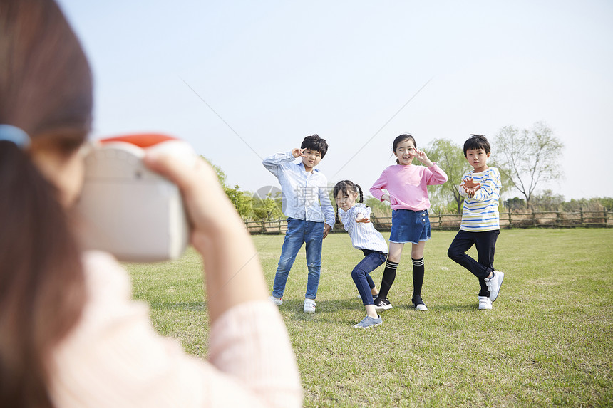 女孩在公园给朋友们拍照图片