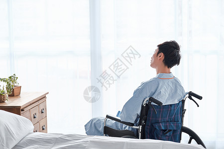 日常生活残疾后背坐在轮椅上的男人图片