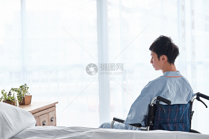 障碍屏障孤独的坐在轮椅上的男人图片