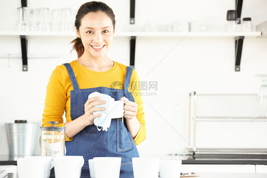 擦咖啡杯的青年女子图片