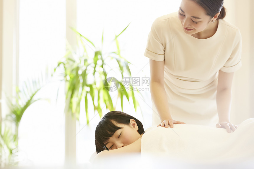 女性spa技师为顾客背部按摩图片