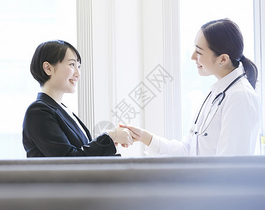 与患者握手的年轻女子高清图片