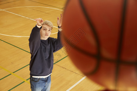 篮球场投篮的青年男子图片