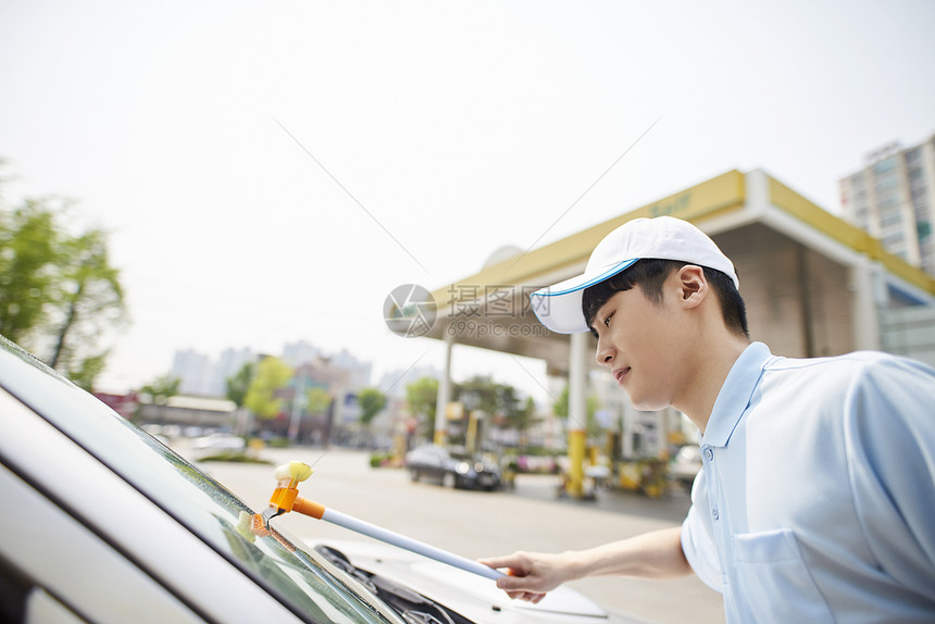 使用工具洗车的成年男子图片