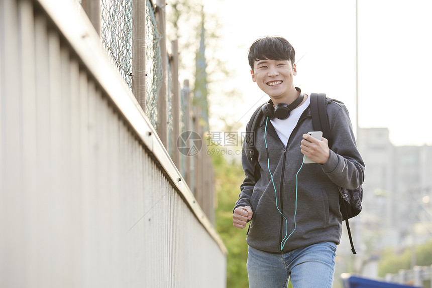 户外戴耳机的男性图片