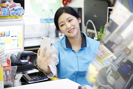 拿着手机的便利店员工背景图片