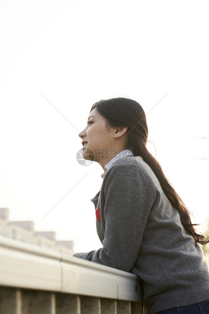 趴在栏杆上的女性图片