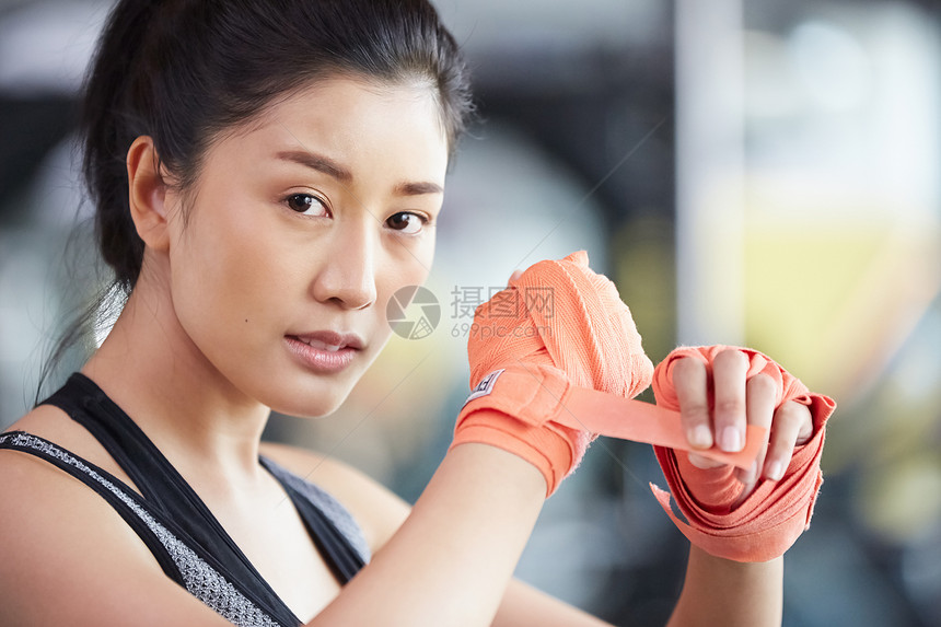 健身房戴上拳击手套的女子图片