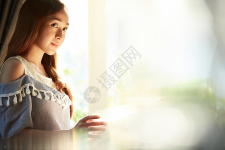 居家站在窗边的年轻女子图片