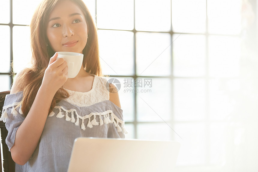 拿着咖啡微笑的女青年图片