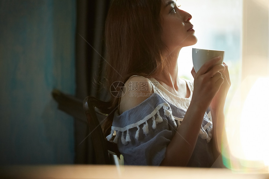 喝咖啡放松的年轻女子图片