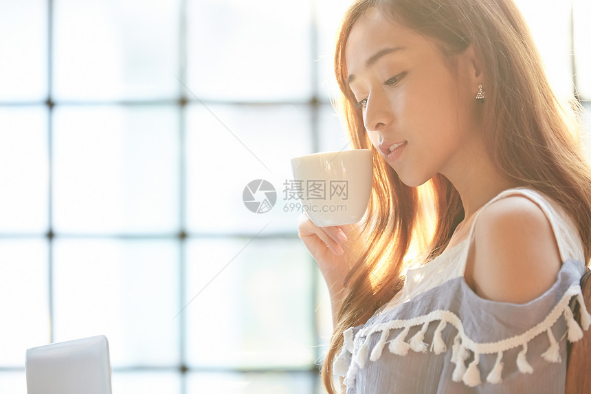 青年女子低头喝咖啡图片
