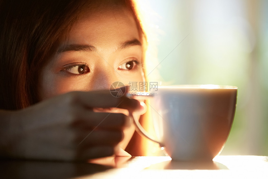 看着咖啡杯的年轻女子图片