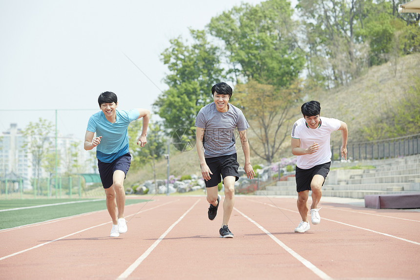 三个青年在跑道上赛跑图片