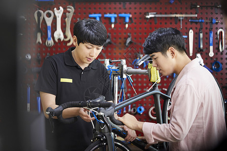 男孩子在修理组装自行车图片