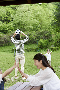 户外踢足球的一家人图片