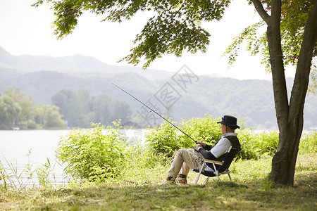 退休老人户外河边钓鱼背景图片