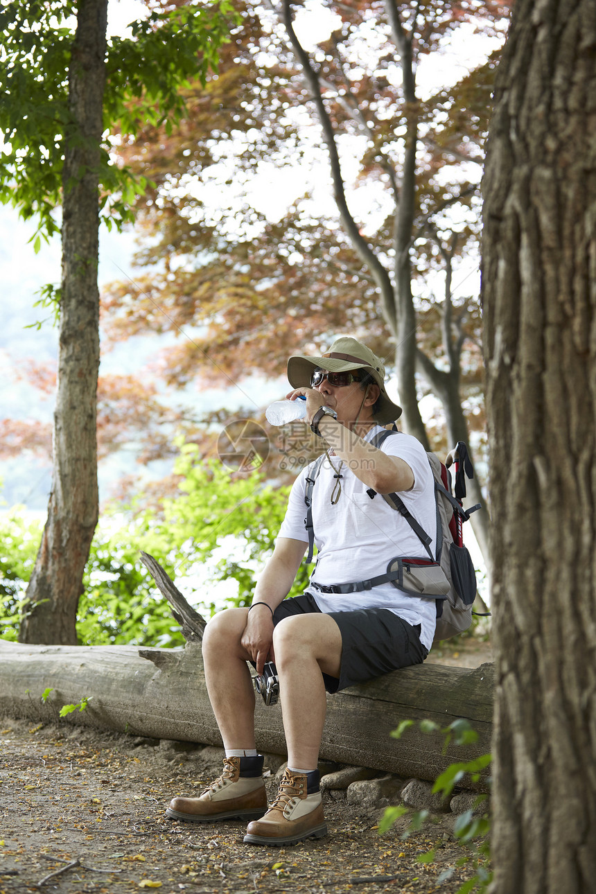 登山休息喝水的背包客图片