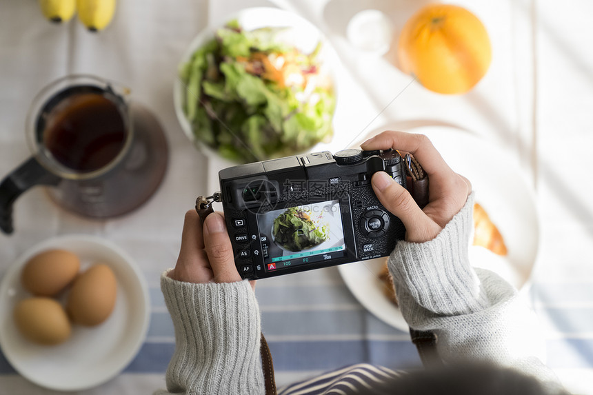 拿着相机拍食物照片图片