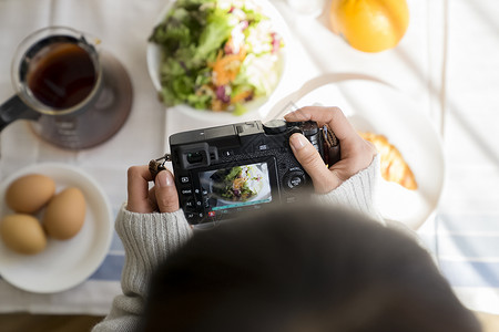 拿着相机拍食物照片特写图片
