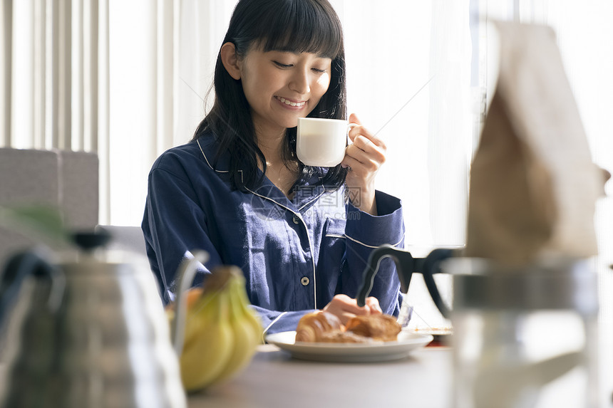 居家吃早餐喝咖啡的年轻女子图片