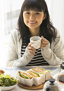 早餐拿着咖啡微笑的女子图片