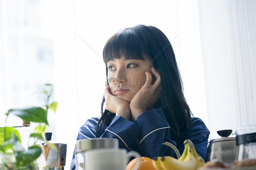 居家早餐托着脸的年轻女子图片