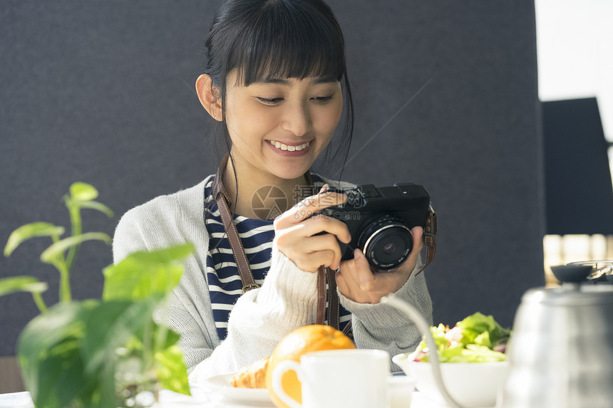 拿着相机微笑的年轻女子图片