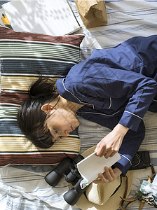 居家躺在床上阅读的女青年图片